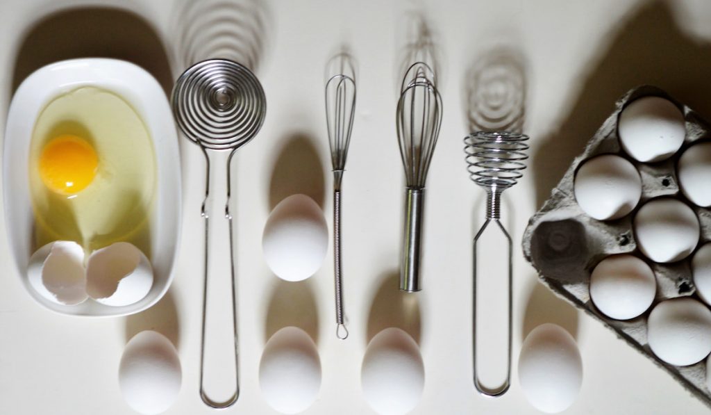 An arrangement of eggs and kitchen utensils. Cooking in the kitchen. Food flat lay. 