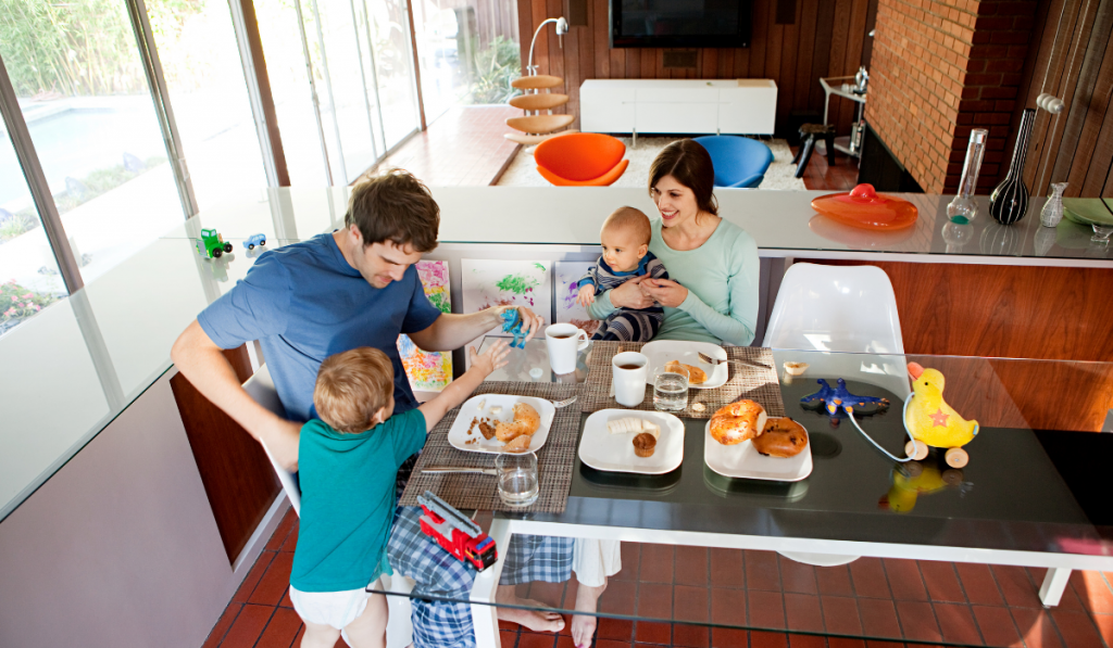 family with a toddler and a baby enjoying breakfast in table