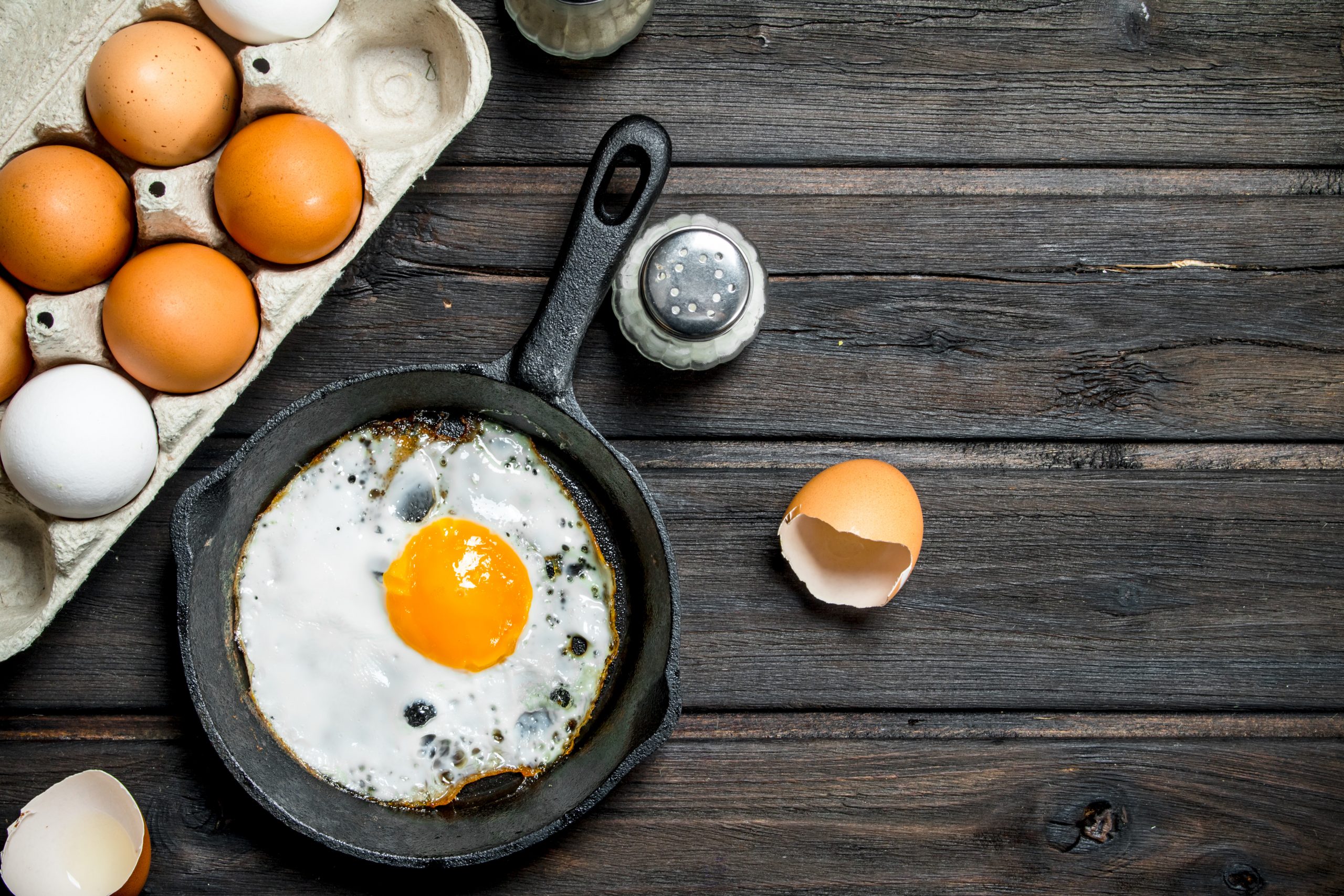 Fried-Egg-in-a-Frying-Pan-and-whole-eggs-on-tray