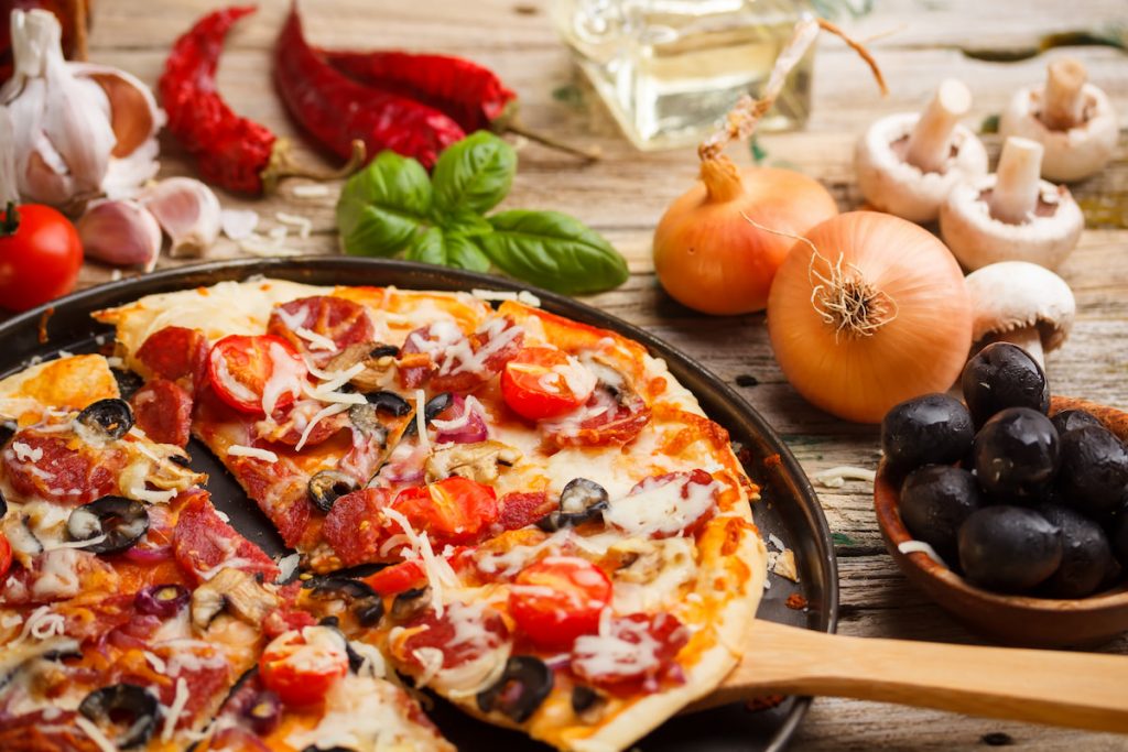 Homemade pizza with onion mushroom pepper olive on table background 