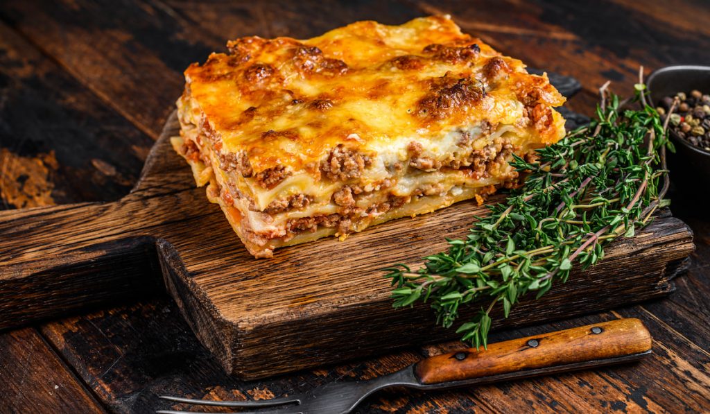 Italian Lasagna with Bolognese sauce and mince beef Dark Wooden background