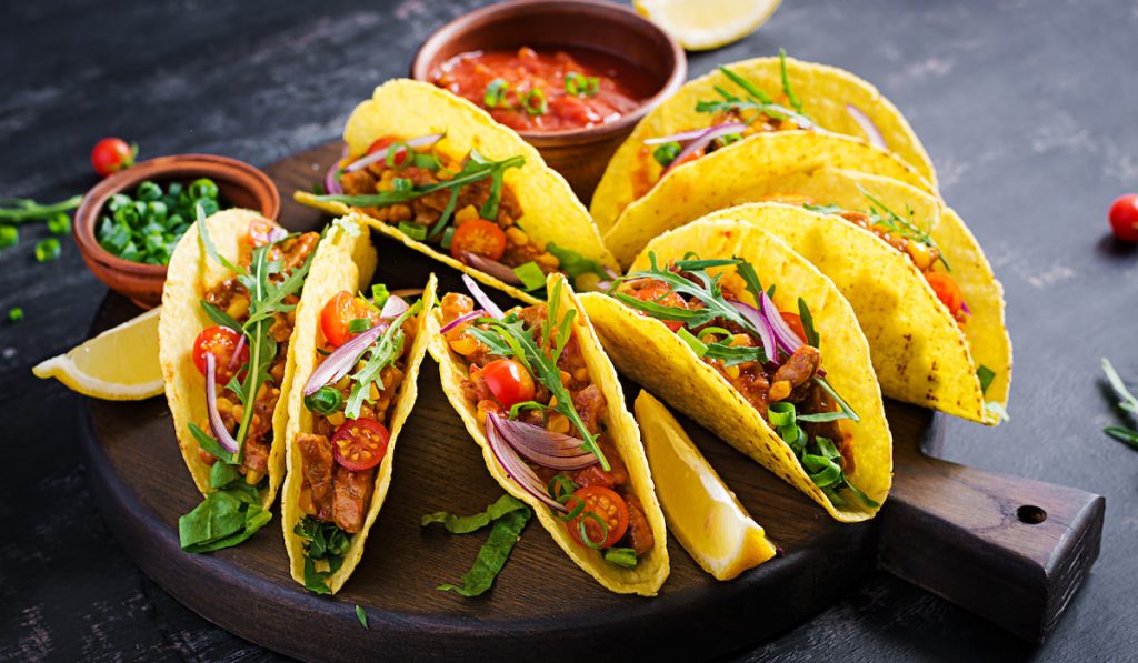 Mexican-tacos-with-beef-meat-corn-and-salsa-on-round-chopboard