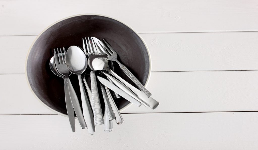 forks and spoons in a black bowl 