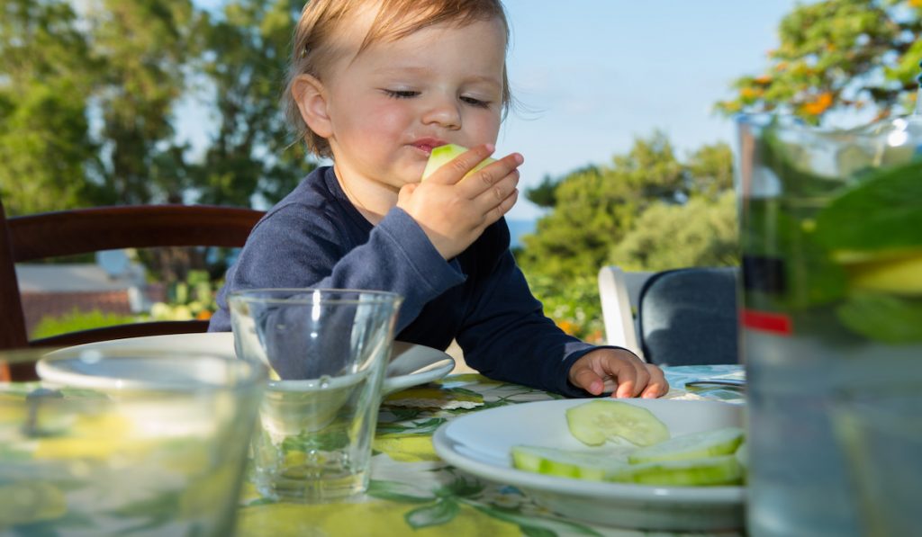 toddler eating an apple outdoors