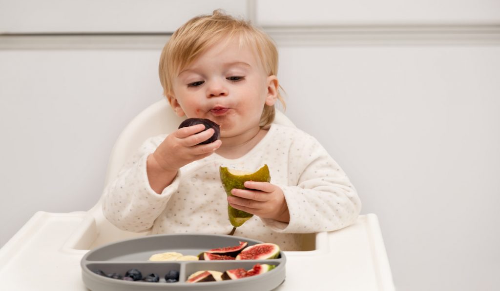 toddler enjoying eating her dinner