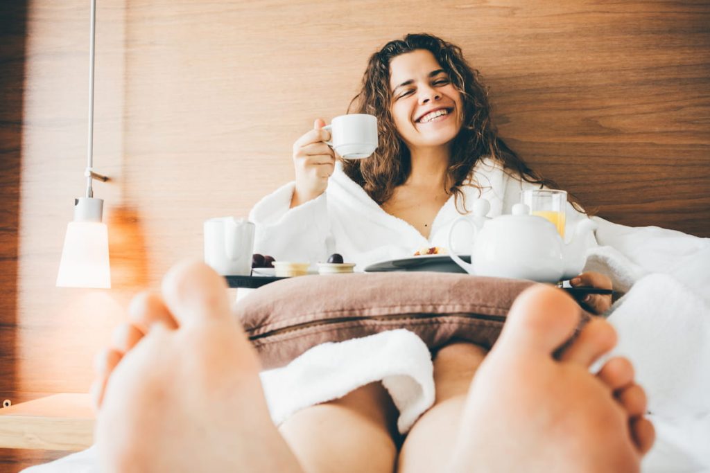 woman having breakfast in bed at a hotel
