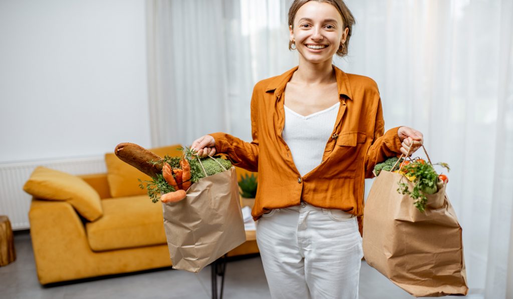 young woman holding bags of groceries